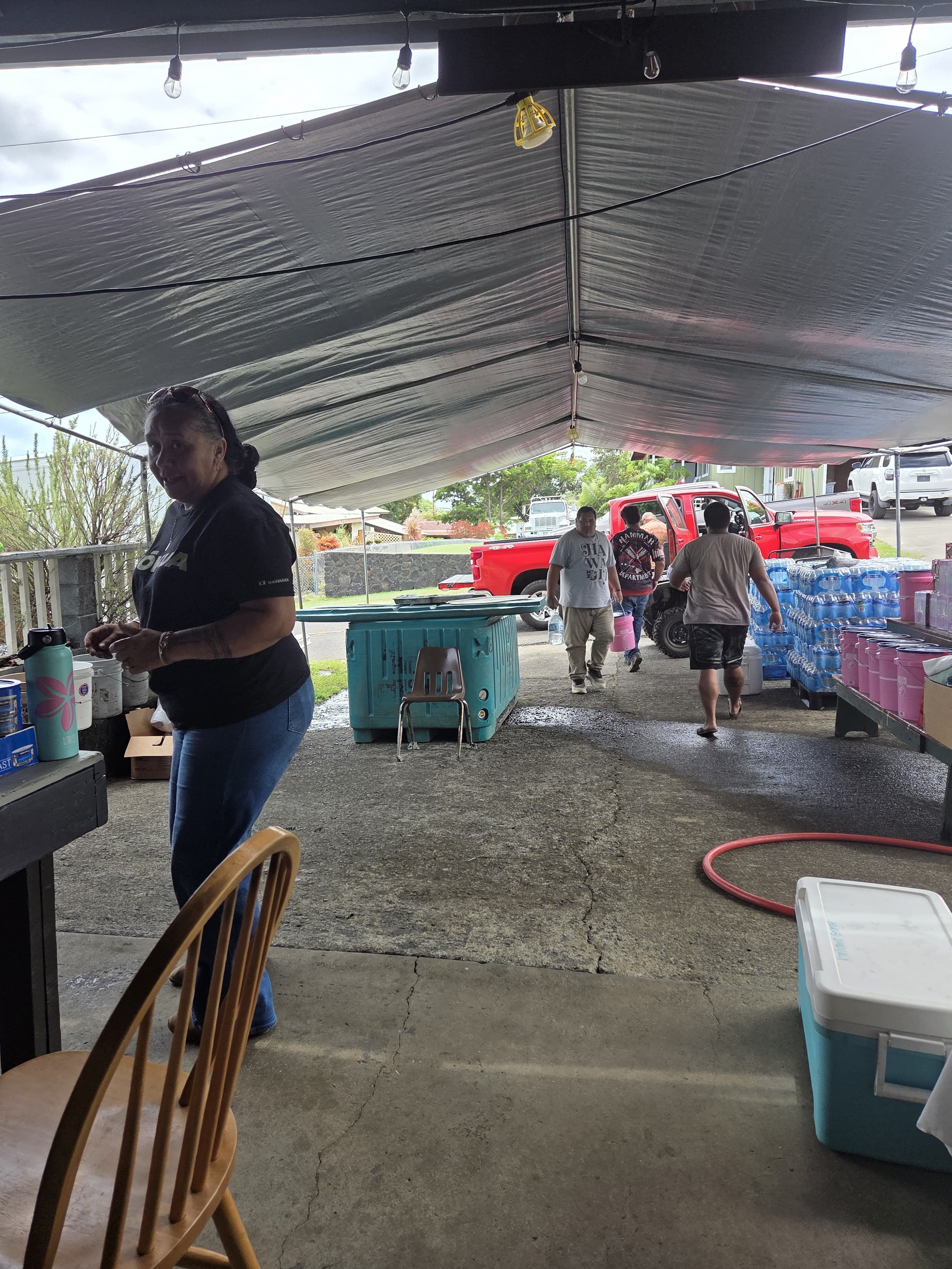 Community members helping receive donated water and emergency supplies