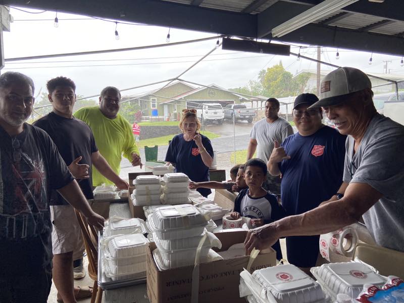Volunteers pack prepared meals during the rain