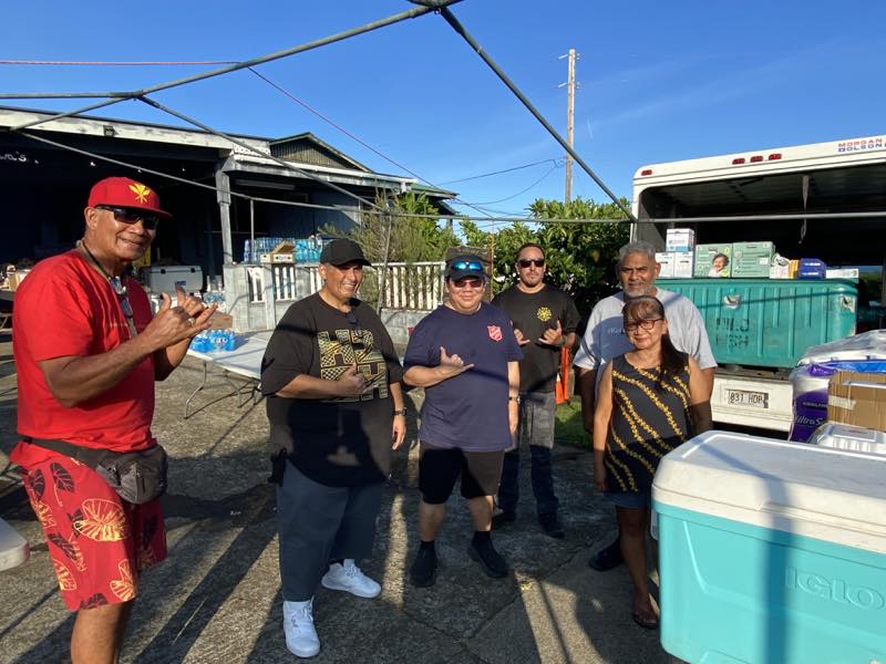 Community partners gather beside relief supplies