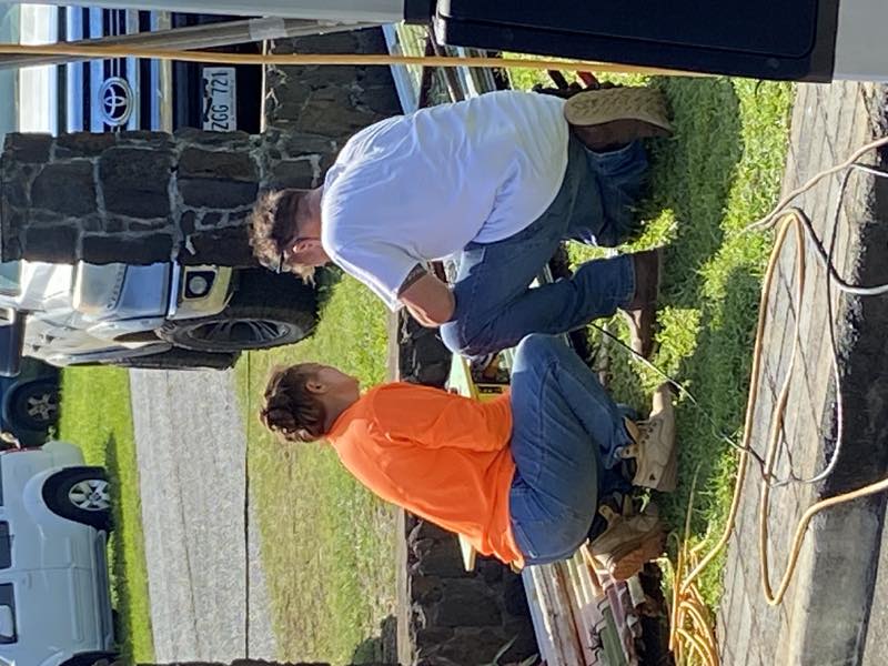 Community members help with equipment repairs