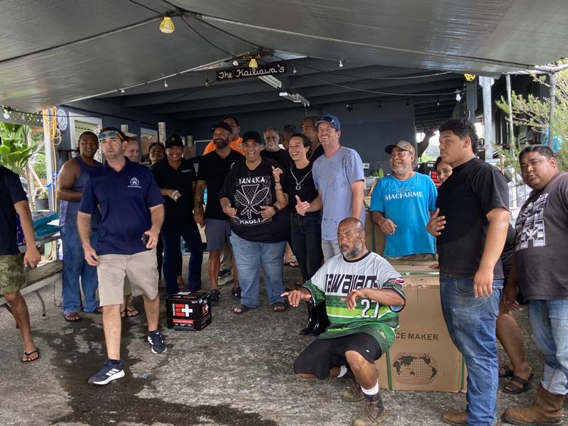 Community volunteers gather under the hub canopy
