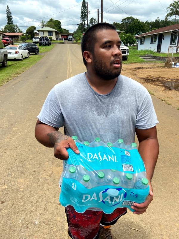 A volunteer carries donated water